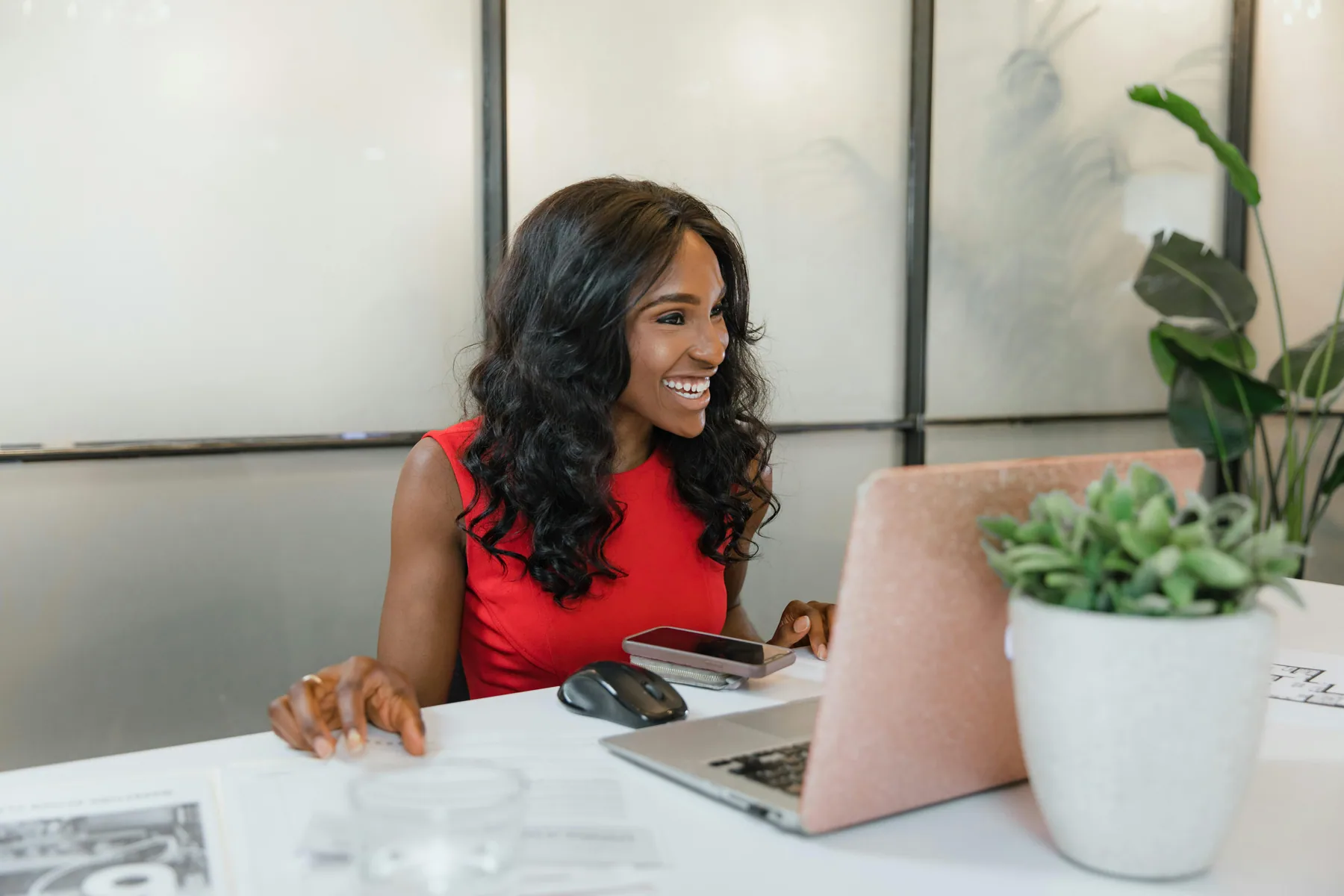 A Black businesswoman in conversation at her desk