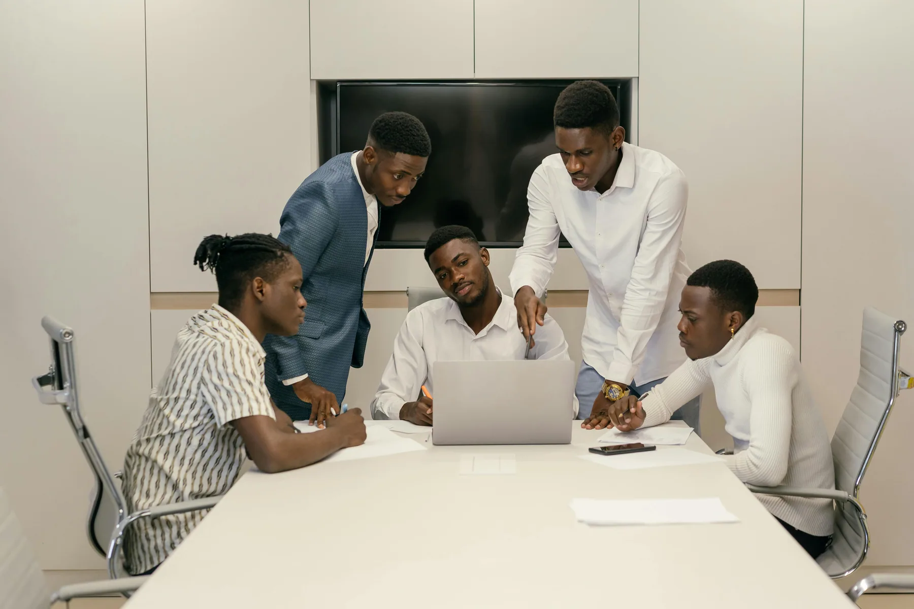Black professionals working together around a laptop